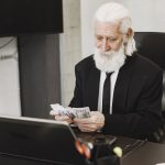 elderly man counting money in office