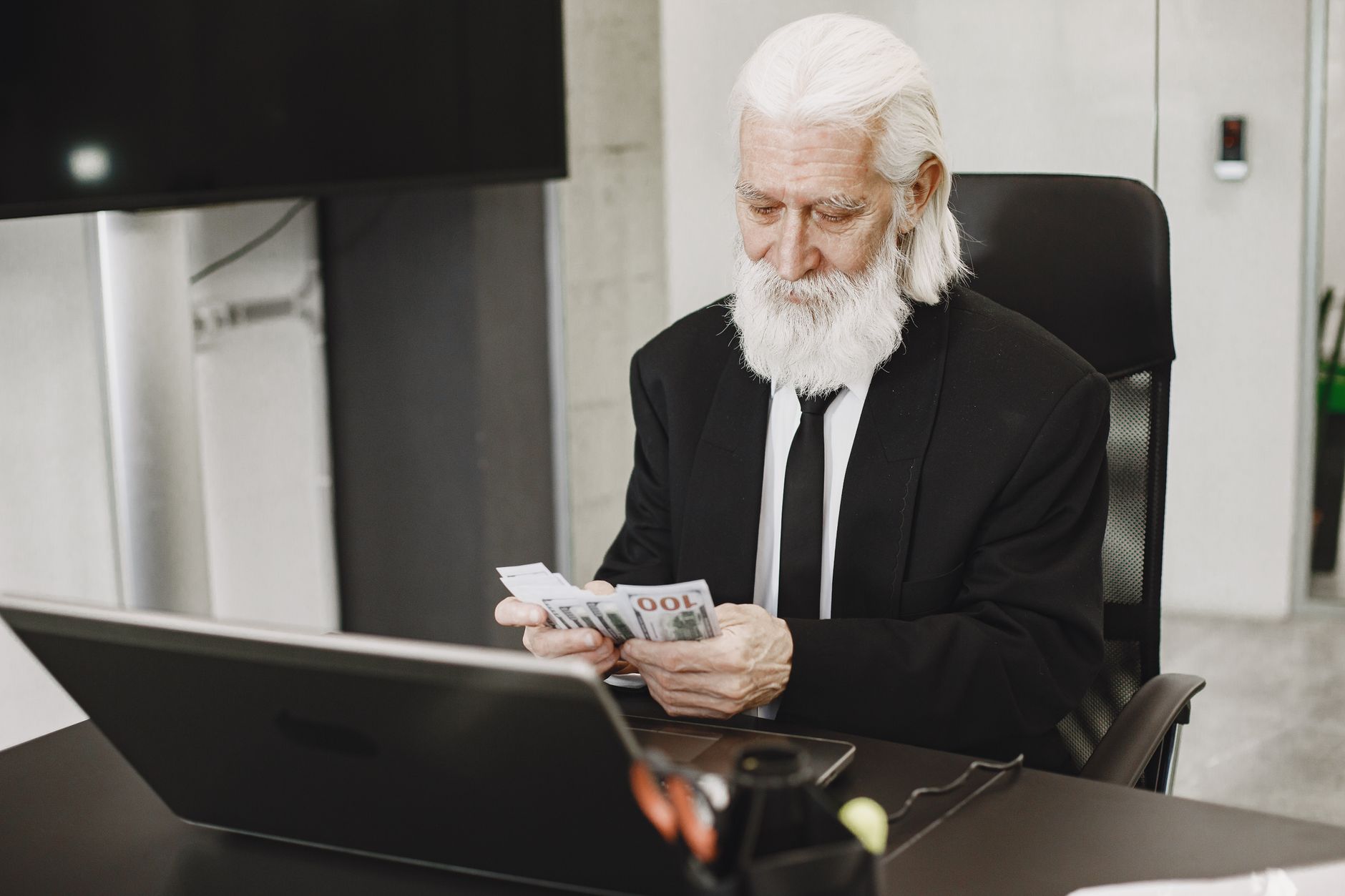 elderly man counting money in office